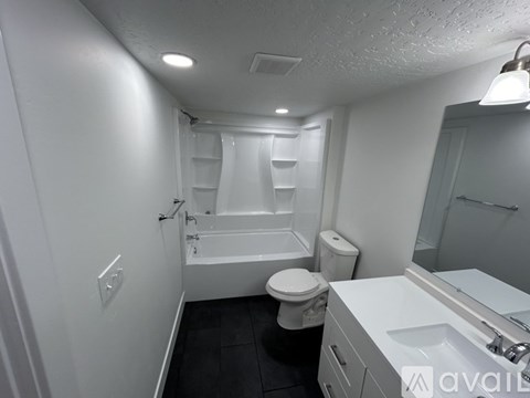 A white bathroom with a toilet, sink, and bathtub.