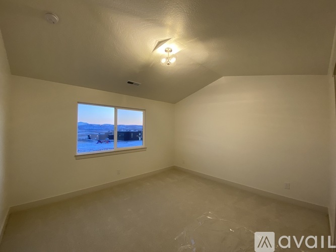 A room with a window overlooking a snowy landscape.