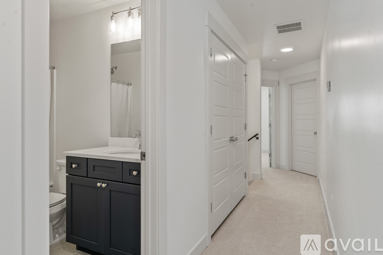 A bathroom with a toilet, sink, and a cabinet.