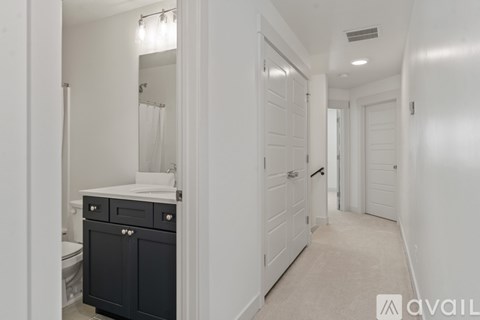 A bathroom with a toilet, sink, and a cabinet.