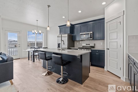 A modern kitchen with a bar stool and a view of the outdoors.