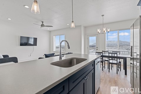 A modern kitchen with a large island and a view of the ocean.