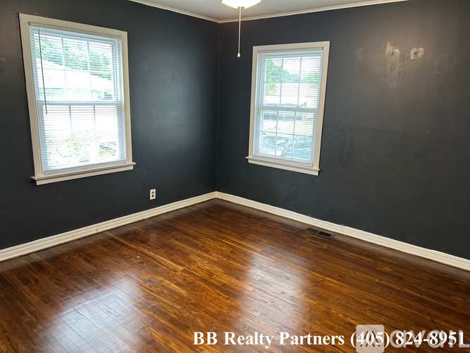 A room with two windows and a BB Realty Partners logo.