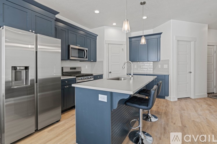 A kitchen with a blue island and stainless steel appliances.