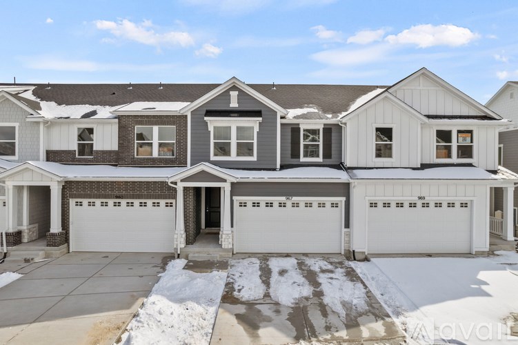 A large, two-story house with a garage and a driveway.