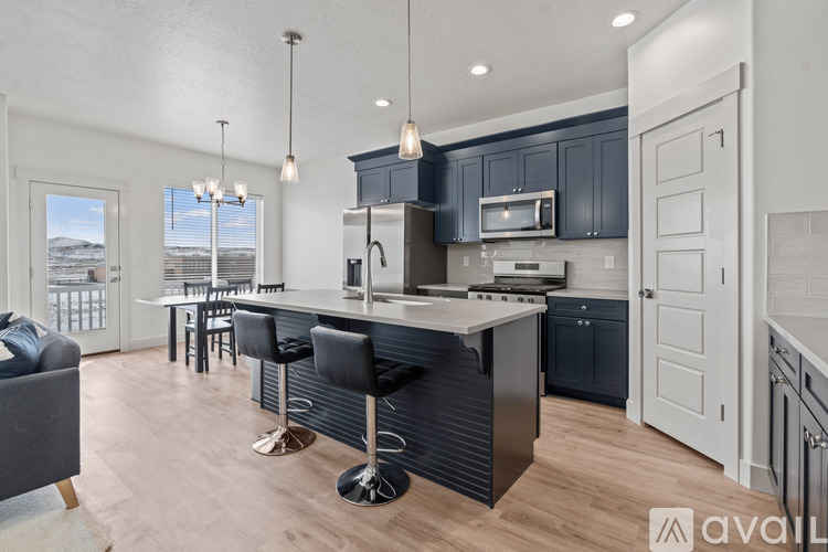 A modern kitchen with a bar stool and a view of the outdoors.