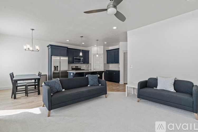 A modern living room with a grey sofa and a dining table.