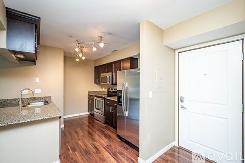 A kitchen with a granite counter top and stainless steel appliances.