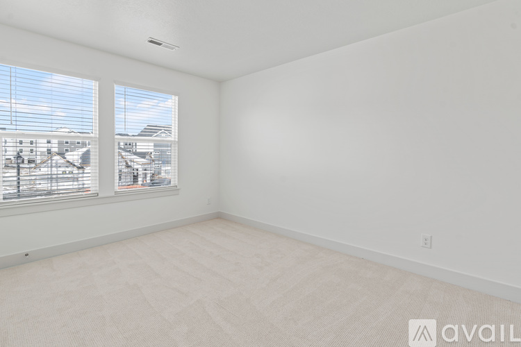 A room with a window overlooking a residential area.