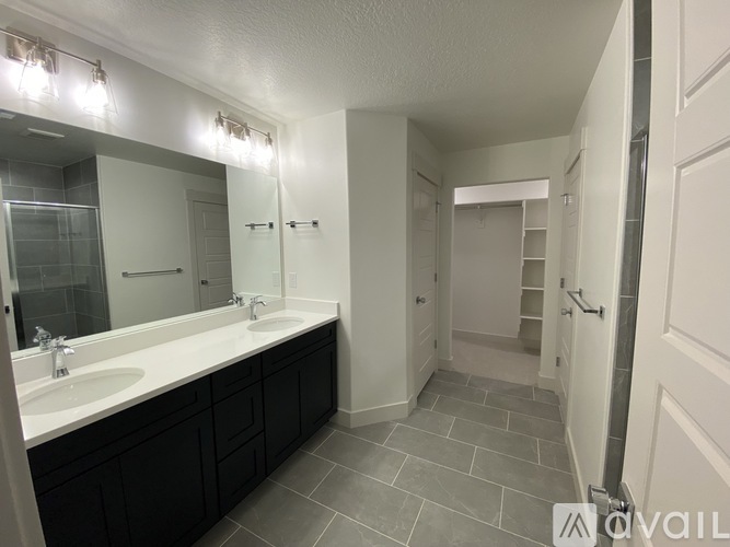 A bathroom with a sink, mirror, and lighting fixtures.