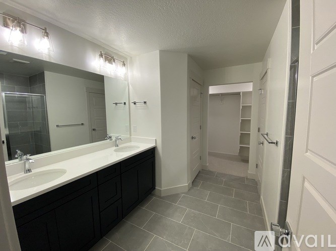 A bathroom with a sink, mirror, and lighting fixtures.