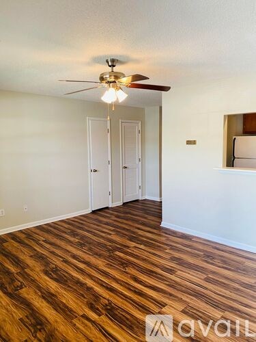 A room with wooden flooring and a ceiling fan.