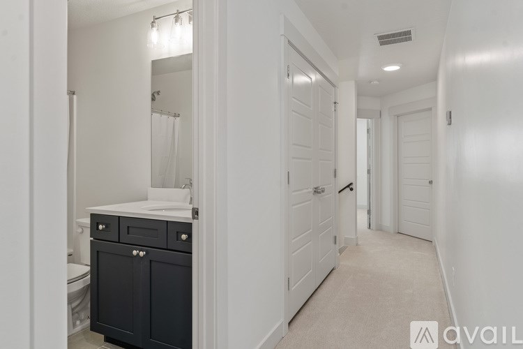 A bathroom with a toilet, sink, and a cabinet.