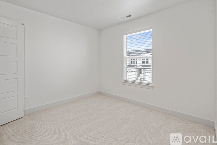 A room with a window showing a house outside.