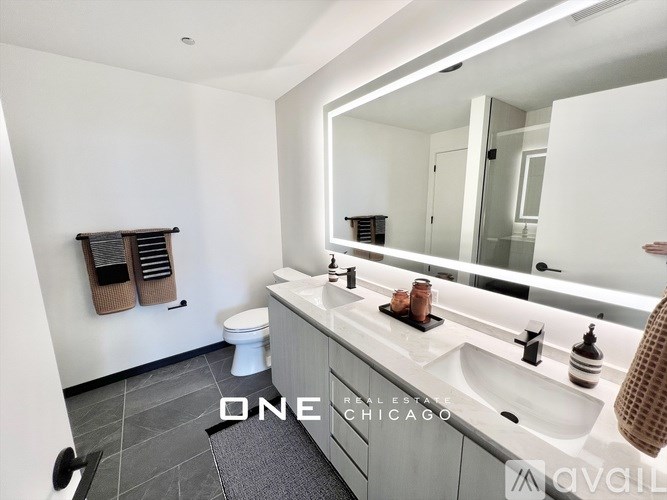 A bathroom with a toilet, sink, mirror and a towel rack.