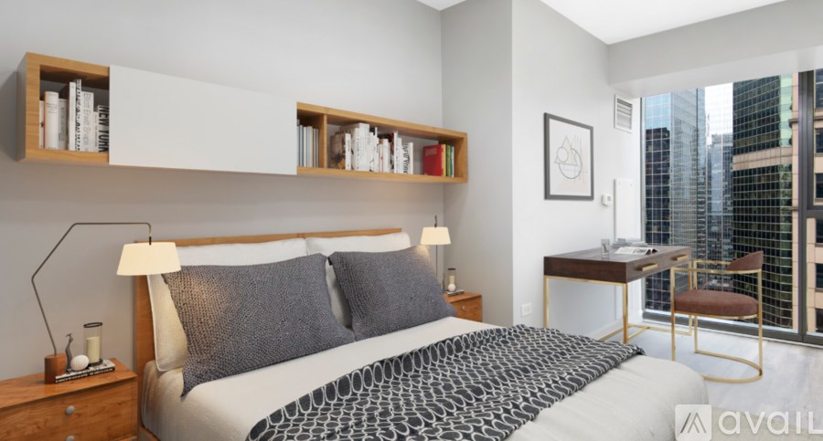 A bedroom with a large bed and a desk with a chair.