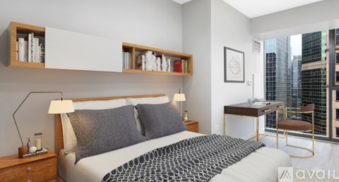 A bedroom with a large bed and a desk with a chair.