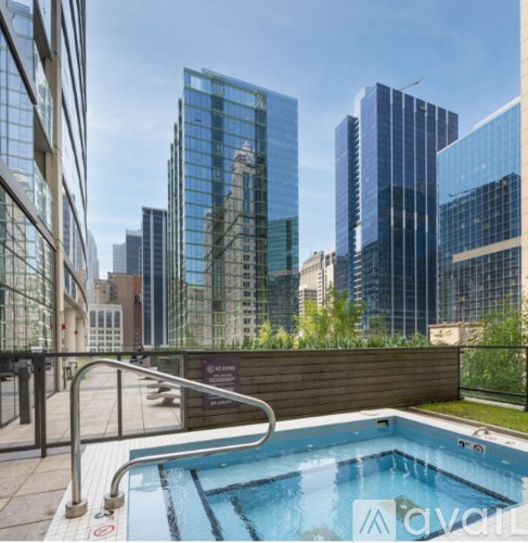 A pool on a balcony with a view of the city.
