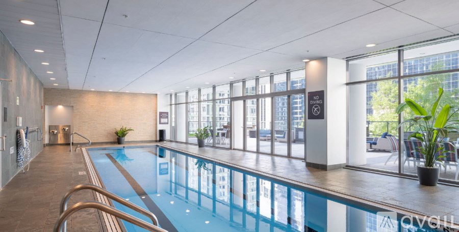 A large indoor swimming pool with a glass wall on one side.