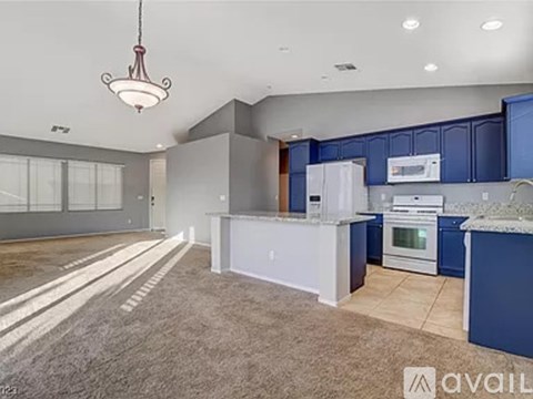 A kitchen with blue cabinets and white appliances.
