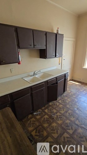 A kitchen with brown cabinets and a patterned floor.