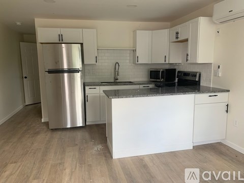 A kitchen with white cabinets and a stainless steel refrigerator.