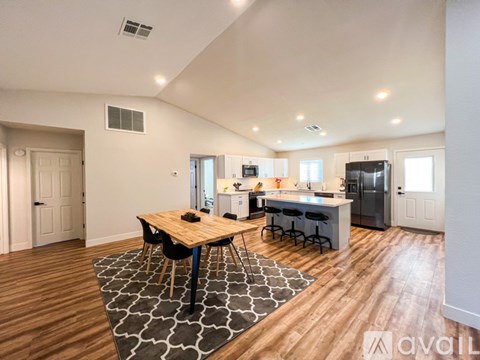 A modern kitchen with a dining table and chairs in the middle of the room.