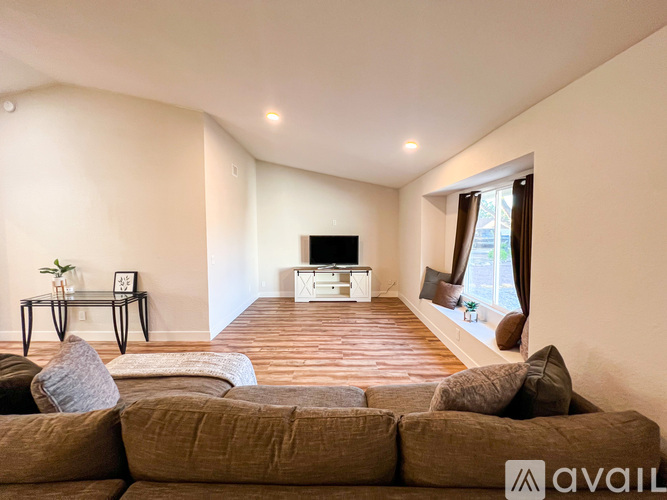 A living room with a brown couch and a television.