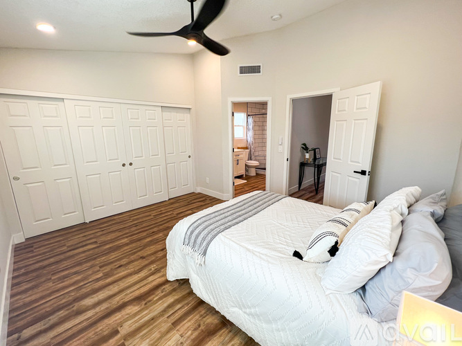 A bedroom with a bed, a ceiling fan, and a closet.
