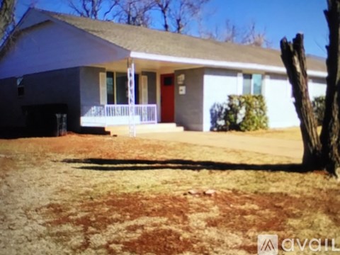 A house with a red door and a white fence.