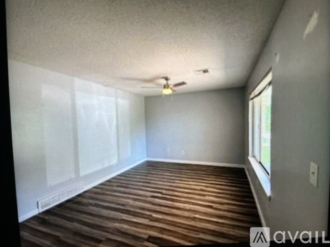 A room with wooden flooring and a ceiling fan.