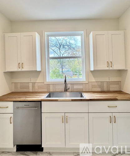 A kitchen with white cabinets and a wooden countertop.