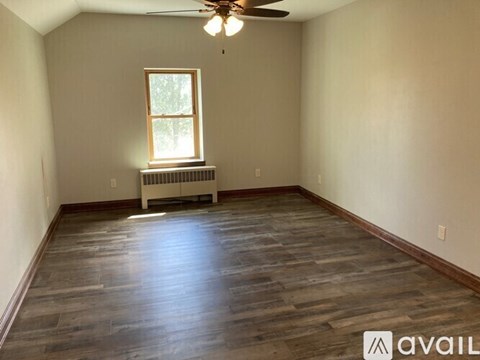 A room with a white door and windows on the side.