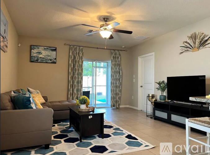 A living room with a brown couch, a coffee table, and a flat screen TV.