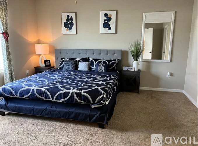 A bedroom with a large bed and a mirror on the wall.