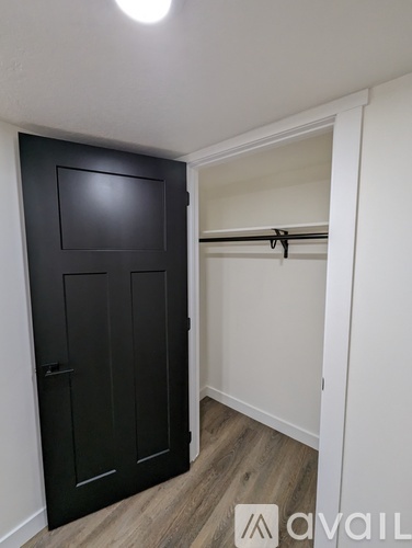 A black door is in a white room.