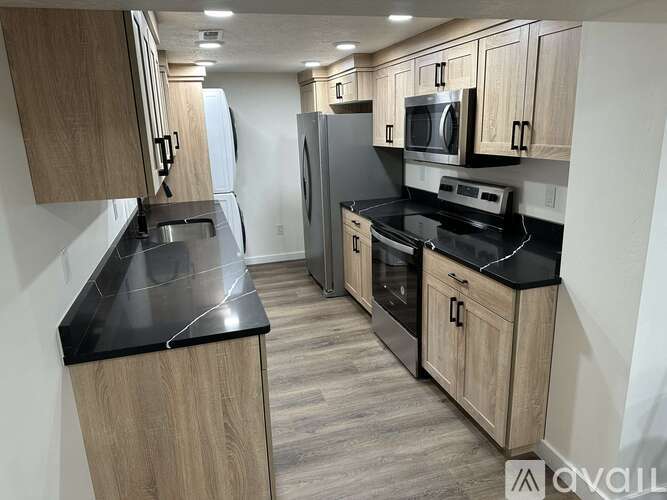 A kitchen with wooden cabinets and black countertops.