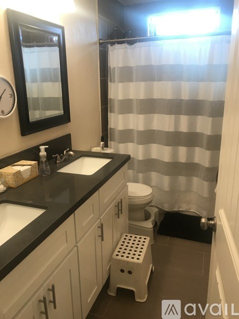 A bathroom with a toilet, sink, and shower curtain.