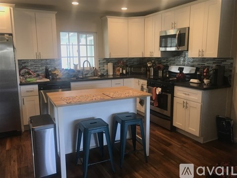 A kitchen with white cabinets and a black countertop.