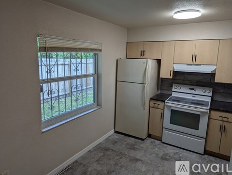 A kitchen with a white refrigerator and stove top oven.