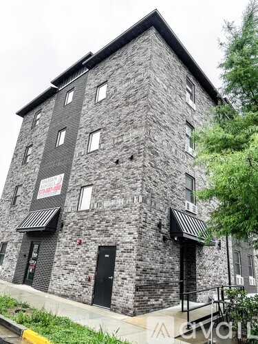 A grey stone building with a black awning and a sign that says "The Ship".