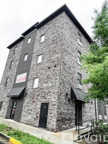 A grey stone building with a black awning and a sign that says "The Ship".