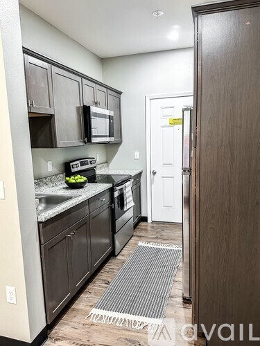 A kitchen with a white fridge and black cabinets.