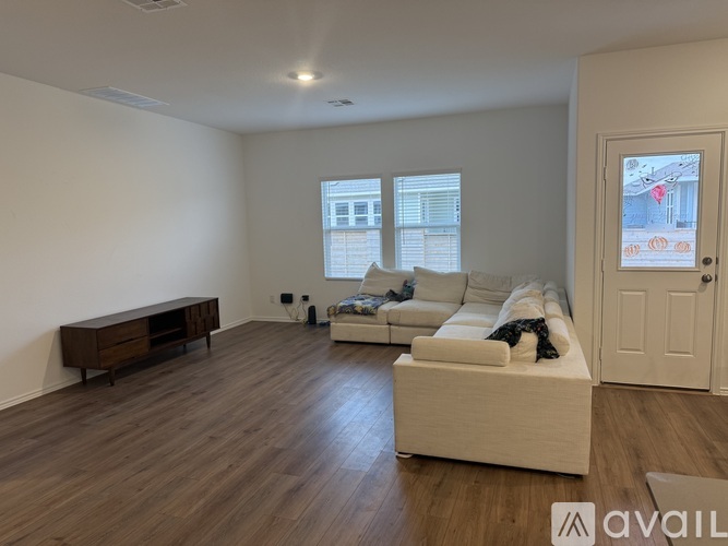 A living room with a white couch and a wooden cabinet.