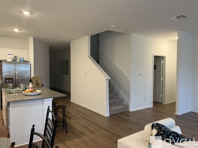 A kitchen with a dining table and chairs is visible.