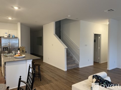 A kitchen with a dining table and chairs is visible.
