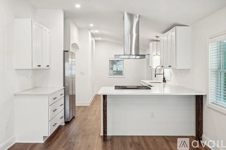 A modern kitchen with white cabinets and a wooden island.