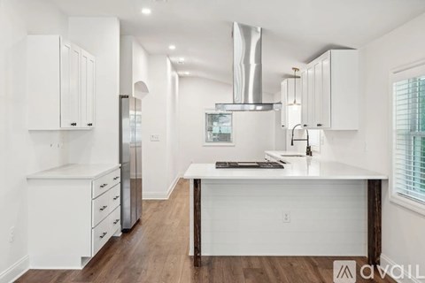 A modern kitchen with white cabinets and a wooden island.
