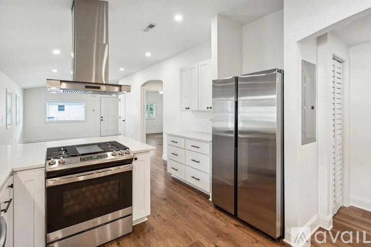 A modern kitchen with stainless steel appliances and white cabinetry.