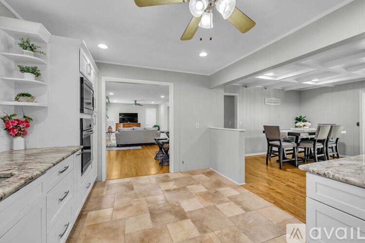 A kitchen with a marble countertop and a ceiling fan.